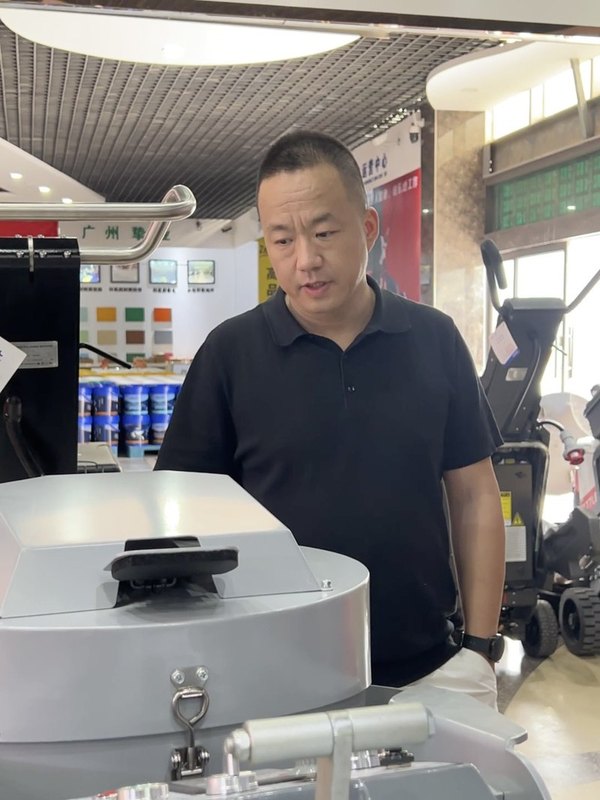 一位外贸从业者站在设备旁，准备为客户讲解真实产品