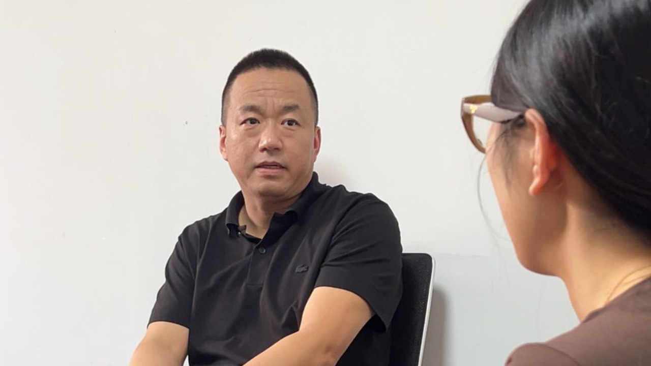 峰哥在办公室与来访者面对面讲解外贸短视频拍摄方法