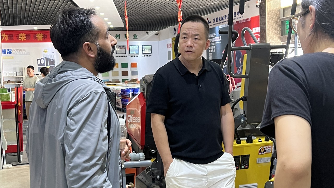 峰哥在设备展厅接待海外客户，现场讲解混凝土地面研磨机