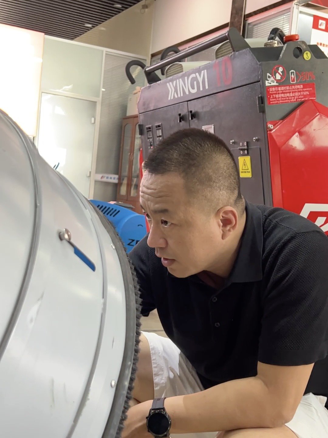 峰哥在工厂展厅检查设备状态，外贸社媒运营的短视频素材就来自日常的工厂和产品现场